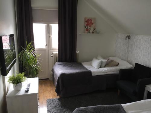 a small room with a bed and a couch at Höjdens Lågprishotell in Mönsterås
