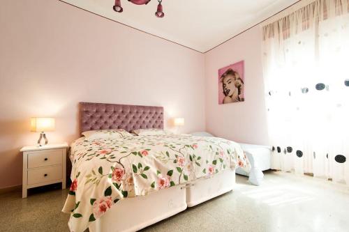 a white bedroom with a bed with a floral bedspread at la loggia in Brindisi