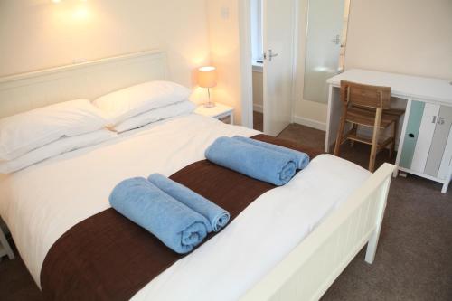 ストロムネスにあるHarbour Cottageのベッドルーム1室(白い大型ベッド1台、青いタオル2枚付)