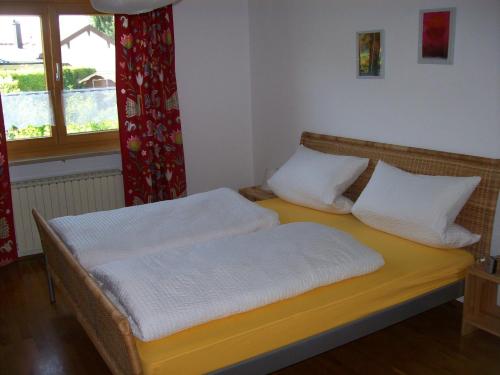 a bedroom with two beds with white sheets and a window at Ferienhaus Irger in Marquartstein