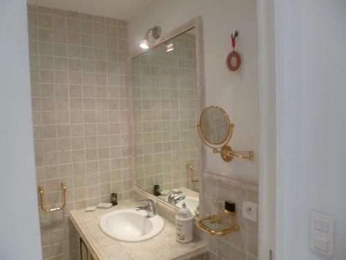ein Badezimmer mit Waschbecken und Spiegel in der Unterkunft Résidence Le Président - Forville in Cannes