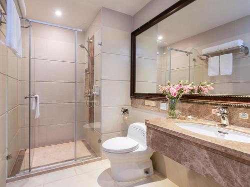 y baño con aseo, lavabo y ducha. en Vienna 3 Best Hotel Guangzhou Zengcheng Xintang Harbour Avenue, en Zengcheng