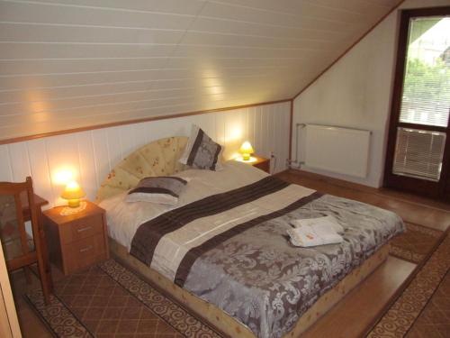 a bedroom with a large bed with two lamps at A+S Penzion Podzamok in Spišské Podhradie