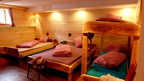 a room with three bunk beds in a cabin at Hostel Weisses Rössl in Leutasch
