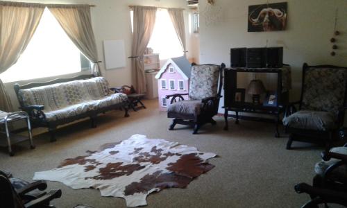 a living room with a rug on the floor at Grysbok Self Catering Accommodation in Oudtshoorn