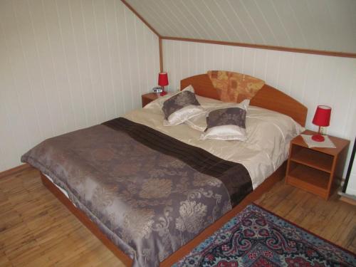 a bedroom with a bed and a table with a red lamp at A+S Penzion Podzamok in Spišské Podhradie
