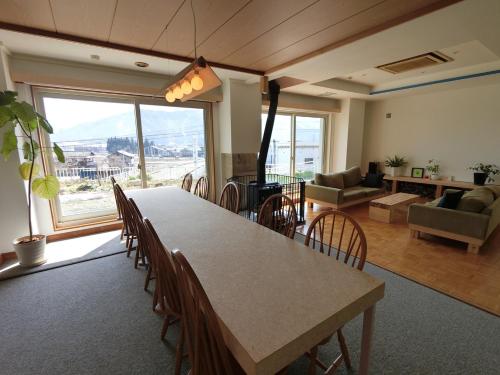 a living room with a large table and chairs at Muikamachi Hutte in Minami Uonuma