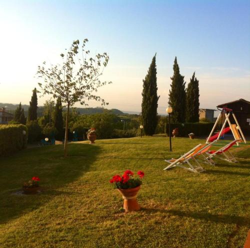a garden with flowers in a pot and a chair at Agriturismo il Prato in Palaia