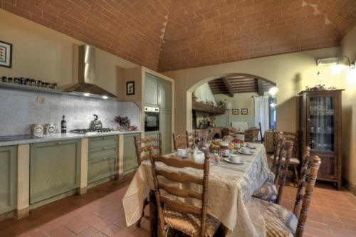 a dining room with a table and a kitchen at Agriturismo il Prato in Palaia
