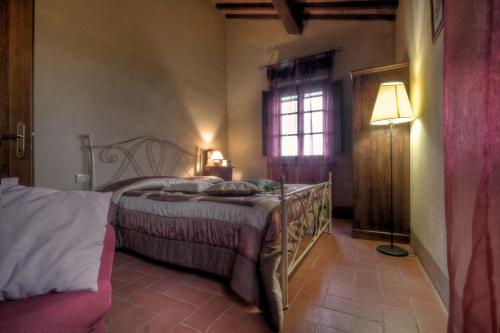 a bedroom with a bed and a lamp and a window at Agriturismo il Prato in Palaia
