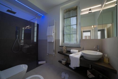 łazienka z umywalką, toaletą i lustrem w obiekcie Cascina36 B&B w mieście Pregnana Milanese