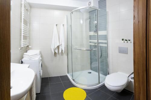 y baño con ducha, aseo y lavamanos. en Apartamenty Kołobrzeg Osiedle Polanki, en Kołobrzeg