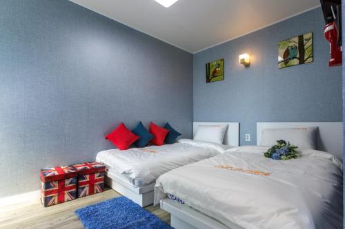 2 Betten in einem Zimmer mit roten und blauen Wänden in der Unterkunft Myeongdong Sunshine Guesthouse in Seoul