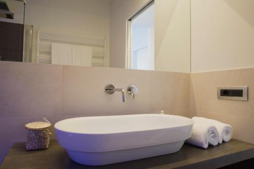 a white tub in a bathroom with a mirror at Cascina36 B&B in Pregnana Milanese