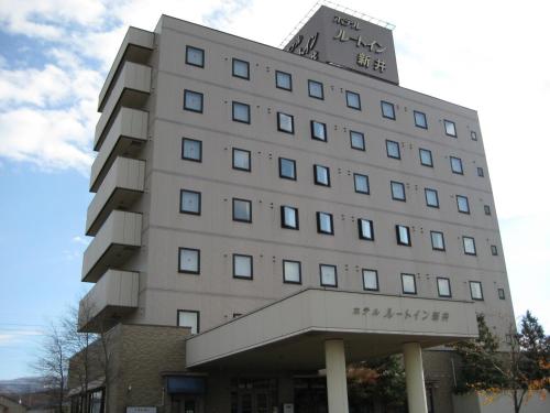 a tall building with a sign on top of it at Hotel Route-Inn Myoko Arai in Myoko