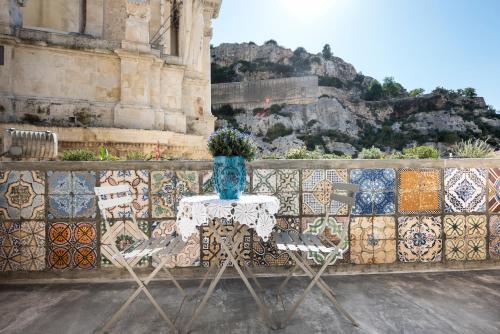 a table with a vase on top of a mosaic wall at Sanbartolomeo Casa & Putìa in Scicli