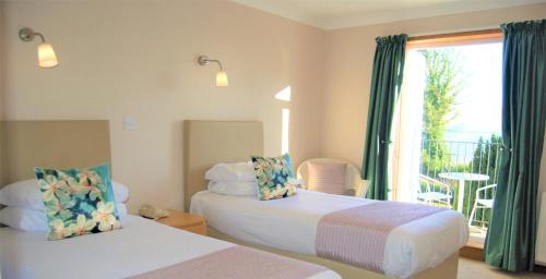 a bedroom with two beds and a window with a patio at Kingswood Hotel in Burntisland