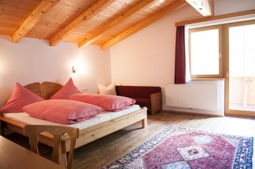 a bedroom with a bed with red pillows on it at Bauernhof Entalhof in Finkenberg