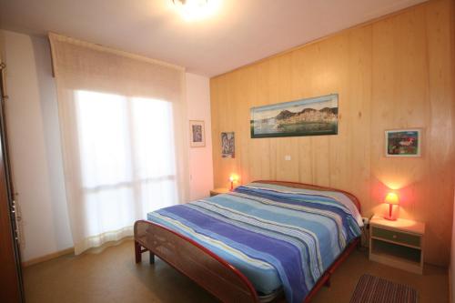 sypialnia z łóżkiem i oknem w obiekcie Michelangelo Apartment w Lignano Sabbiadoro