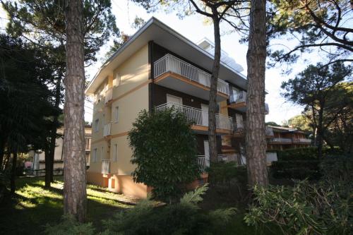 budynek z drzewami przed nim w obiekcie Michelangelo Apartment w Lignano Sabbiadoro