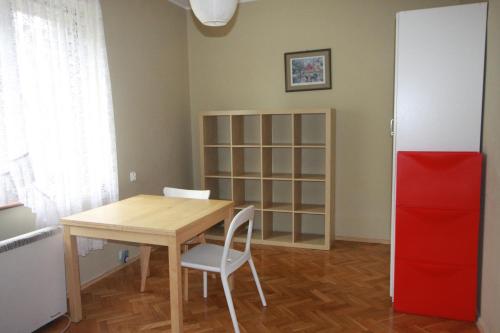 a dining room with a table and a red refrigerator at Little studio in Gdańsk in Gdańsk