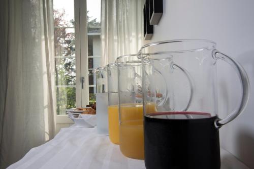 three glasses of orange juice sitting on a table at Cascina36 B&B in Pregnana Milanese
