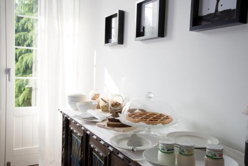 a table with plates and bowls on it with a window at Cascina36 B&B in Pregnana Milanese