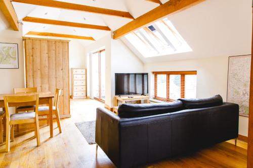a living room with a black couch and a table at The Saracens Head Inn in Symonds Yat