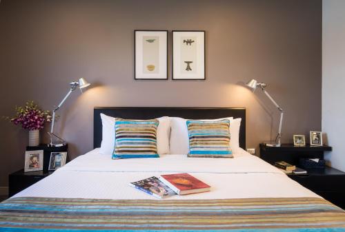 a bed with two lamps and a book on it at Somerset Vientiane in Vientiane