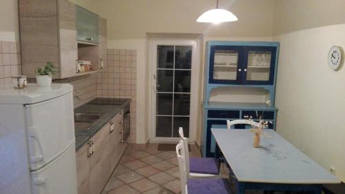 uma cozinha com armários azuis e um frigorífico branco em Apartment Deni em Lumbarda