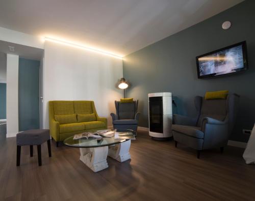 a living room with chairs and a coffee table at Cascina36 B&B in Pregnana Milanese