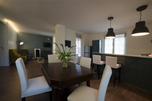 a dining room with a table and white chairs at Cascina36 B&B in Pregnana Milanese