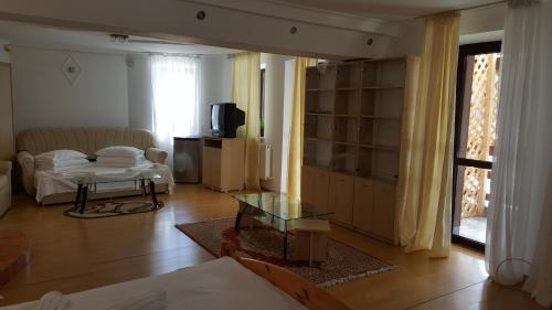 a living room with a couch and a table at Vila Alunis in Buşteni