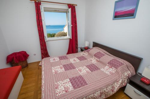 a bedroom with a bed and a window with the ocean at Apartments Silence in Mlini