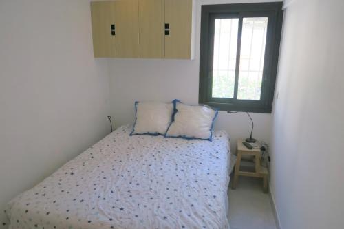 une chambre avec un lit avec deux oreillers dessus dans l'établissement Sol-y-Days California, Superbe appartement rénové en RDC avec Parking, belle terrasse ombragée, à 200m de la plage, au Grau-du-Roi