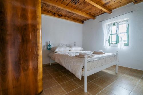 a bedroom with a white bed with a wooden ceiling at Apartman Studio Zdravko Eco Village in Imotski