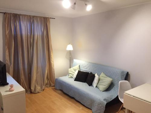 a living room with a blue couch with pillows at Suur-Ameerika Apartment in Tallinn