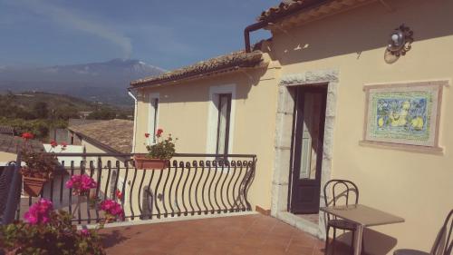 a house with a balcony with a fence and flowers at Villa Laura Apartment in Giardini Naxos