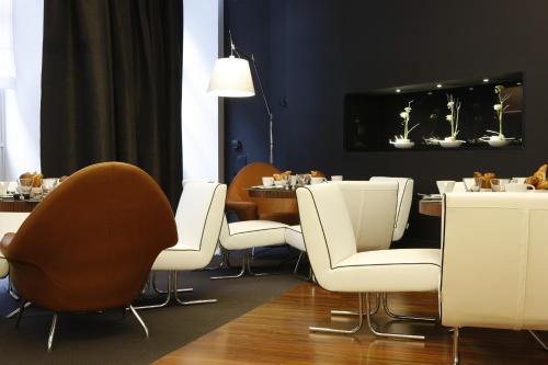 a dining room with white chairs and a table at Le Grand Balcon Hotel in Toulouse