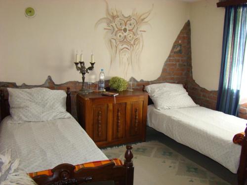 a bedroom with two beds and a table with candles at Bilkarskata Kashta in Gorsko Slivovo