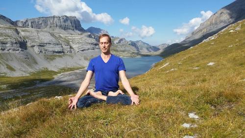 a man doing yoga on a hill in the mountains at Le Bristol Leukerbad in Leukerbad