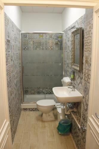 a bathroom with a toilet and a sink and a shower at Victoria House Hostel in Genova