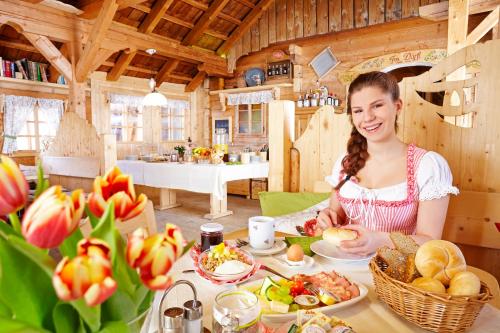 a woman sitting at a table with a plate of food at Im Dörfl Anno 1873 in Irdning
