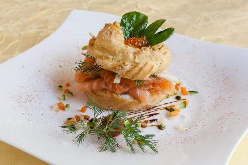a white plate with a sandwich with shrimp on it at Hôtel Restaurant du Château in Rocamadour