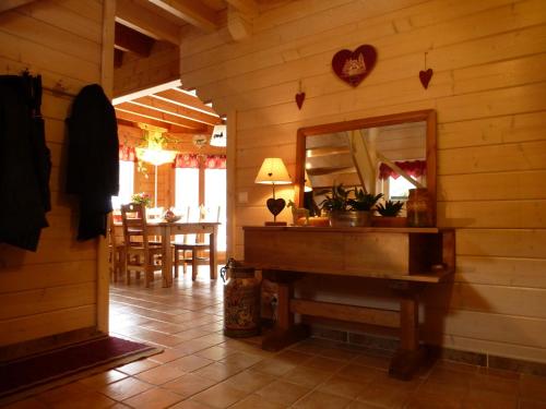 Cette chambre comprend un miroir et un mur en bois. dans l'établissement Le Chalet de Philippe, à La Bresse