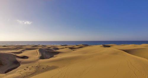 a sandy desert with the ocean in the background at Bohemia Suites & Spa - Adults Only in Playa del Ingles