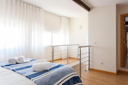 1 dormitorio con 1 cama con 2 toallas en ALTIDO Bright 2BR Apt with River Views &balcony in Alfama, moments from Santa Apolonia train station, en Lisboa