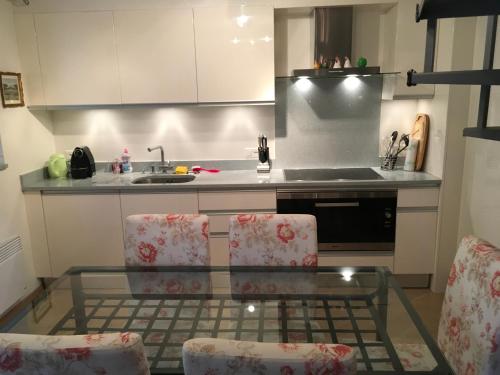 a kitchen with a glass table and two chairs at Ferienhaus, Rustico Auf Burg in Locarno