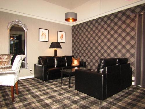 a living room with leather furniture and a mirror at Kingswood Hotel in Burntisland