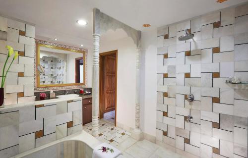 La salle de bains est pourvue d'une baignoire, d'un lavabo et d'un miroir. dans l'établissement Pratap Mahal Pushkar IHCL SeleQtion, à Pushkar